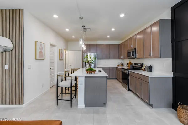 a kitchen with kitchen island granite countertop a sink a counter top space appliances and cabinets
