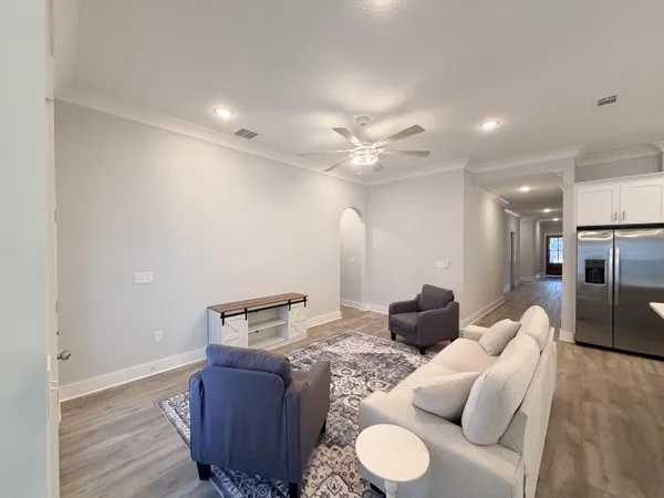 an empty room with a ceiling fan and wooden floor