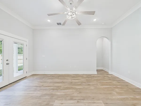 an empty room with a window and a fan