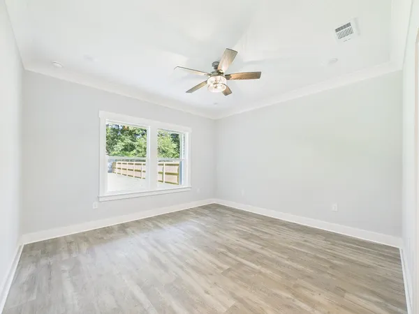 an empty room with a ceiling fan and wooden floor