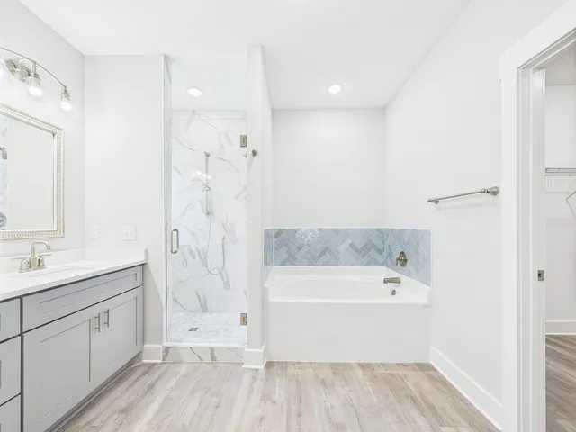 a spacious bathroom with a tub sink shower and mirror