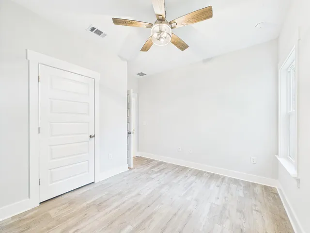 a view of a hallway with wooden floor and closet