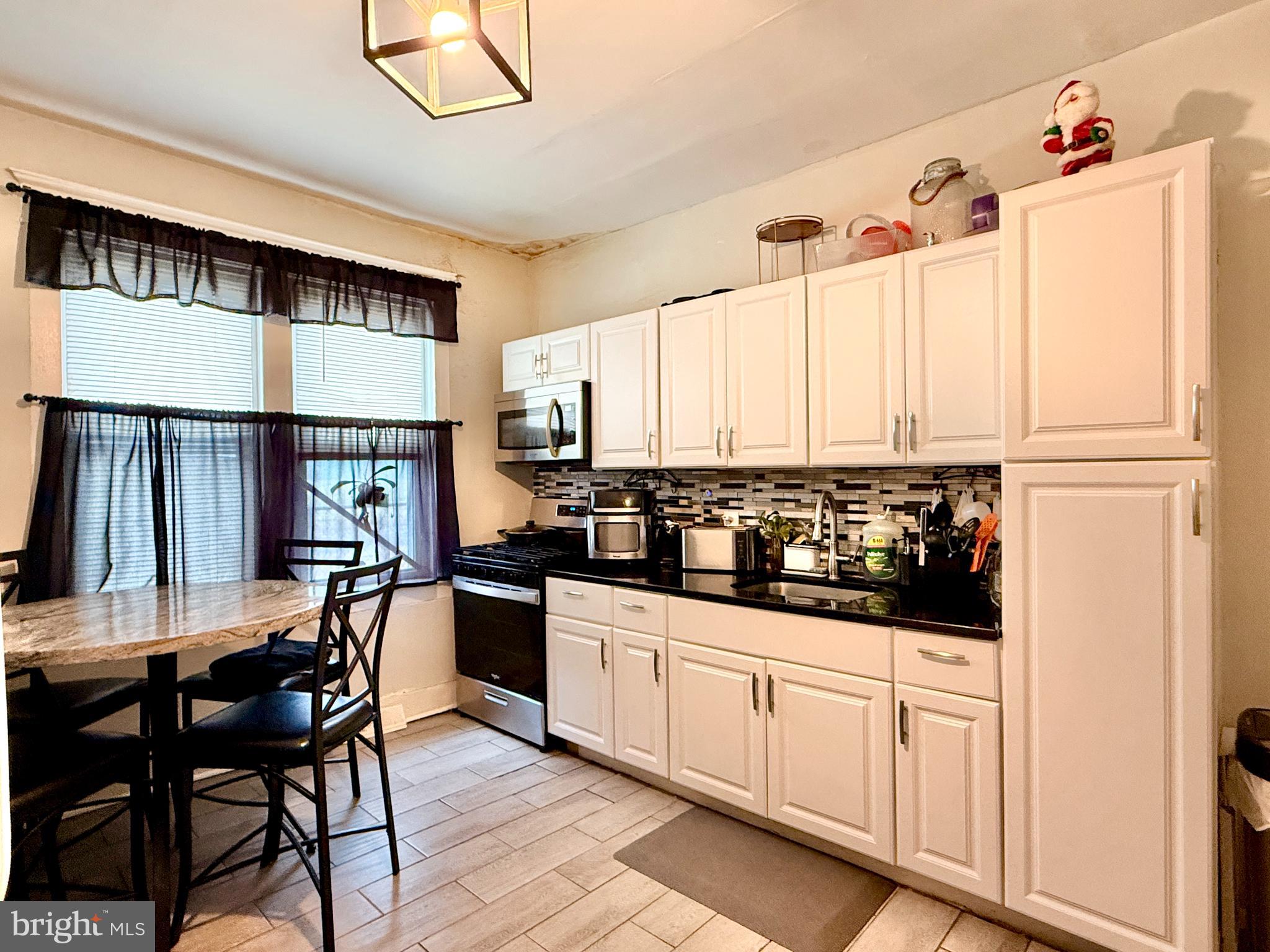 1157 Chestnut Street Camden, NJ 08103 - Photo 7 of 17 a kitchen with white cabinets and white appliances