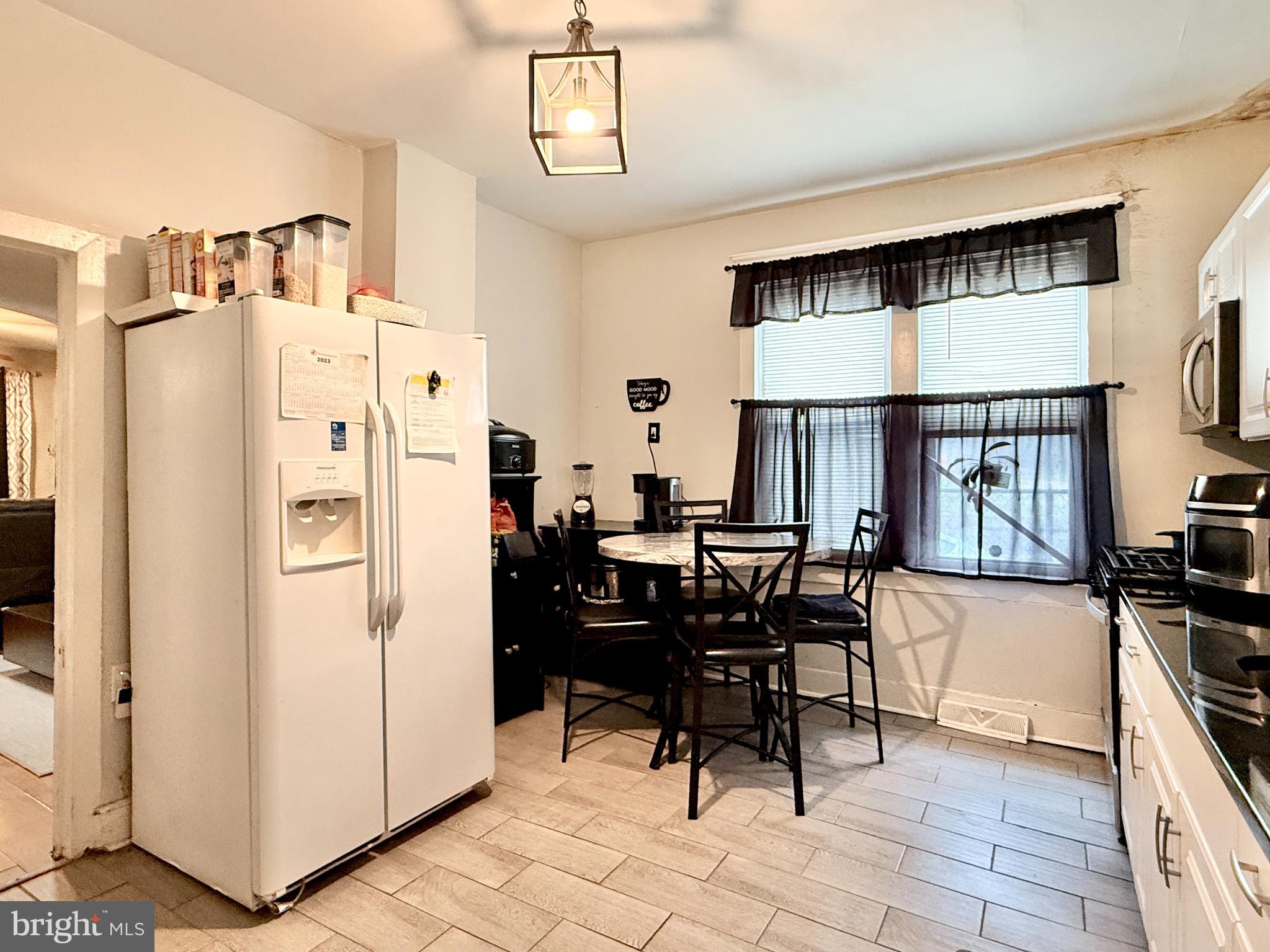1157 Chestnut Street Camden, NJ 08103 - Photo 8 of 17 a dining room with stainless steel appliances kitchen island granite countertop furniture and a refrigerator