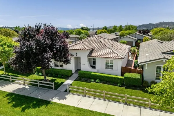 a view of a house with a big yard plants and large trees
