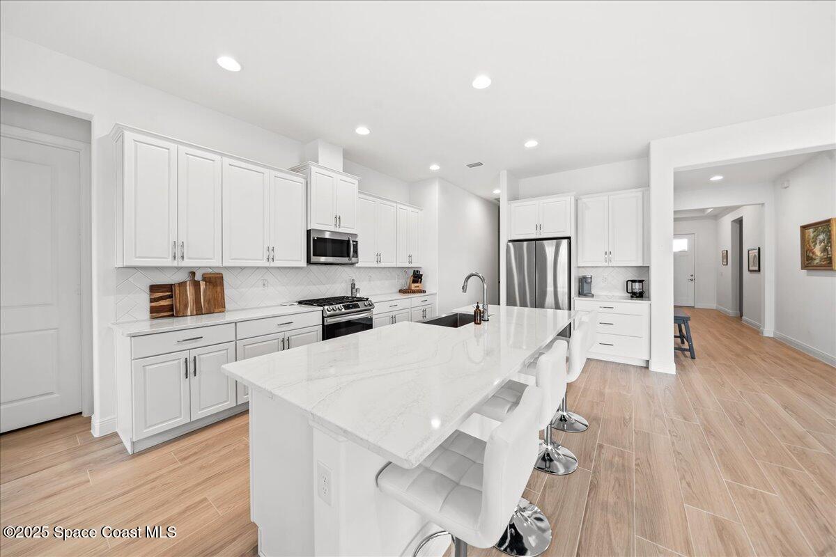 3234 Laming Way Melbourne, FL 32940 - Photo 13 of 59 a large white kitchen with lots of white appliances cabinets and furniture