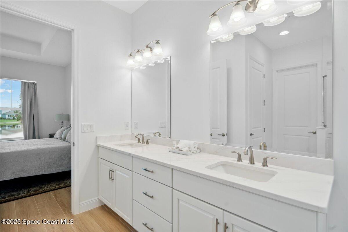 3234 Laming Way Melbourne, FL 32940 - Photo 24 of 59 a en suite bathroom with double vanity a mirror and a bathtub