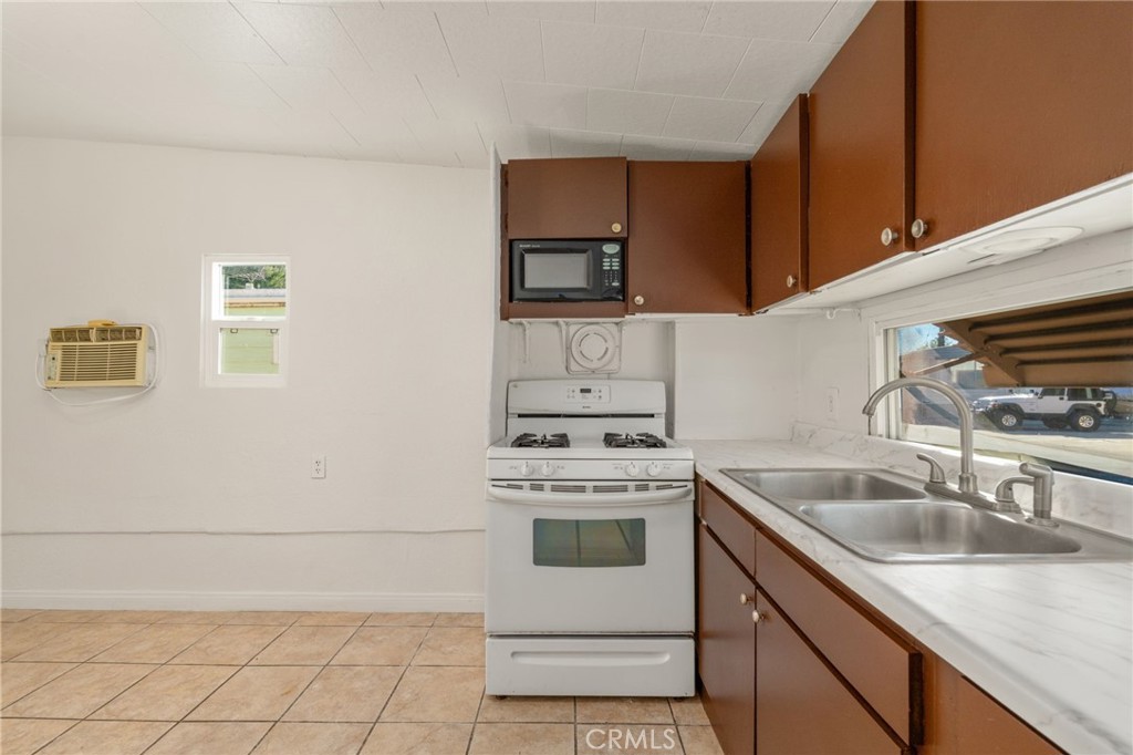 26235 9th Street, Unit 18 Highland, CA 92346 - Photo 7 of 31 a kitchen with granite countertop a sink stove and cabinets