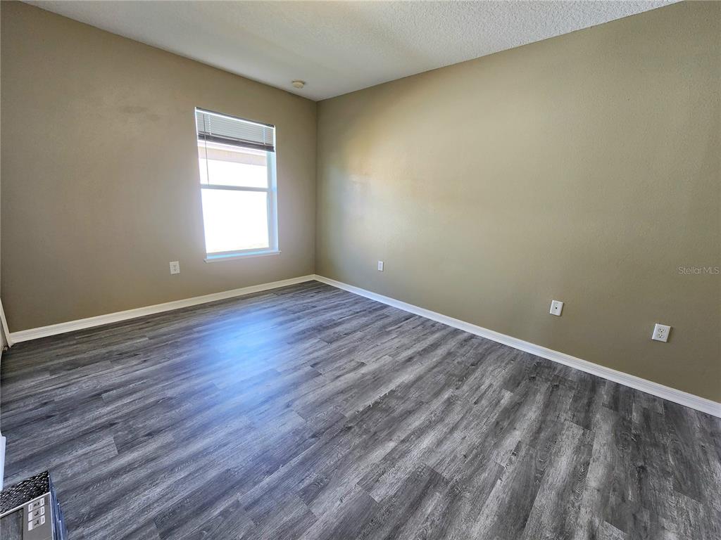 4017 Longworth Loop Kissimmee, FL 34744 - Photo 11 of 22 a view of an empty room with wooden floor and a window
