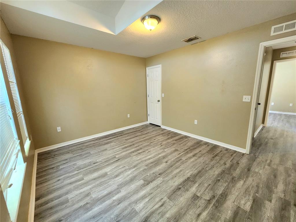 4017 Longworth Loop Kissimmee, FL 34744 - Photo 9 of 22 an empty room with wooden floor and windows