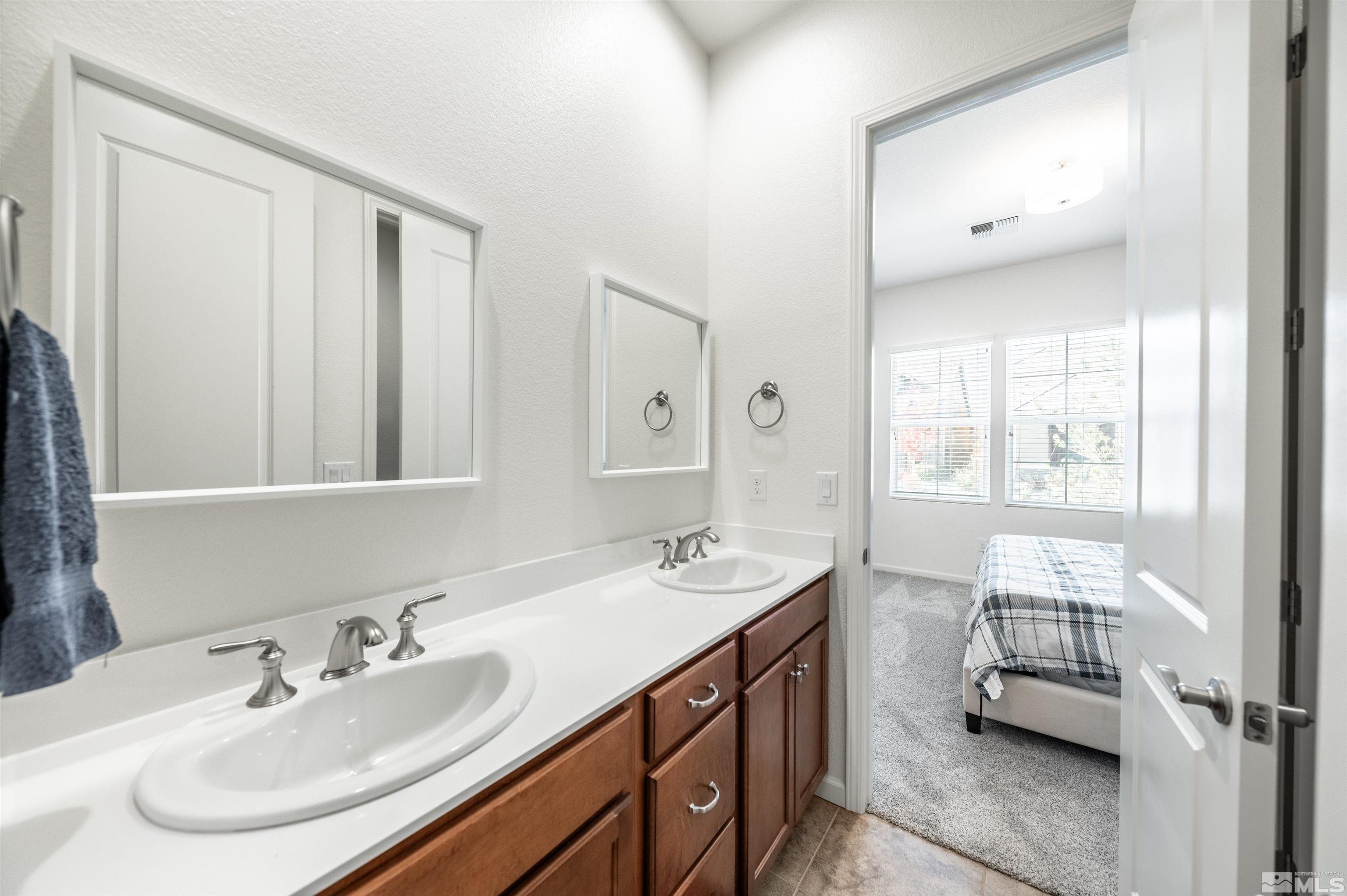 9494 Baldacci Road Reno, NV 89521 - Photo 13 of 34 a en suite bathroom with a double vanity sink and a mirror