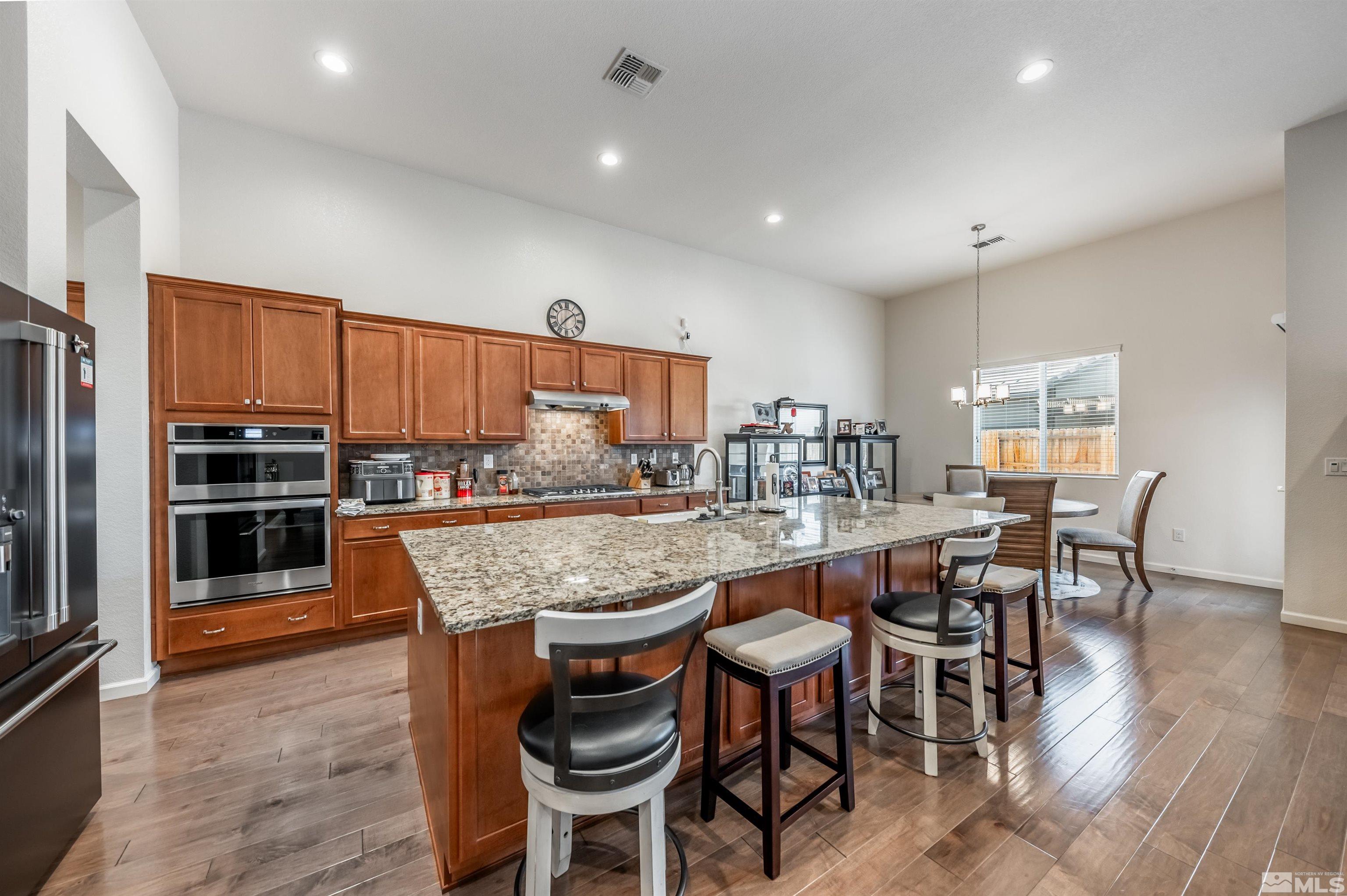 9494 Baldacci Road Reno, NV 89521 - Photo 3 of 34 a kitchen with stainless steel appliances granite countertop table chairs sink and stove