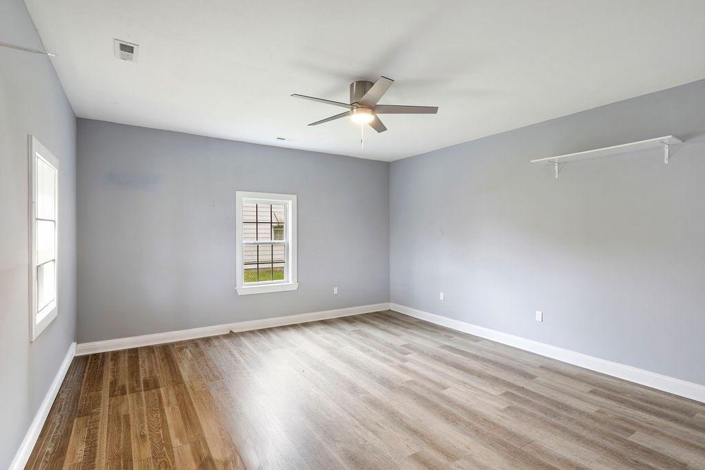 191 Elm Street Trion, GA 30753 - Photo 14 of 25 an empty room with wooden floor ceiling fan and windows