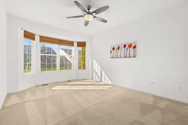 an empty room with closet and windows