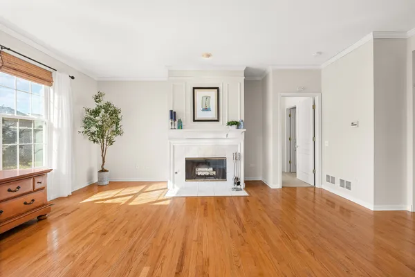 a view of a livingroom with a fireplace window and wooden floor
