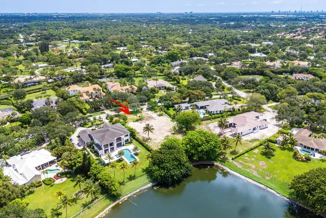 an aerial view of residential houses with outdoor space and trees
