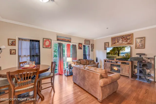 a living room with furniture kitchen view and a flat screen tv