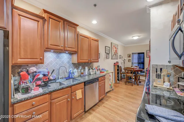 a kitchen with stainless steel appliances granite countertop wooden cabinets a sink and dishwasher