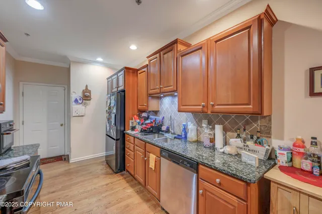 a kitchen with stainless steel appliances granite countertop a sink stove and cabinets