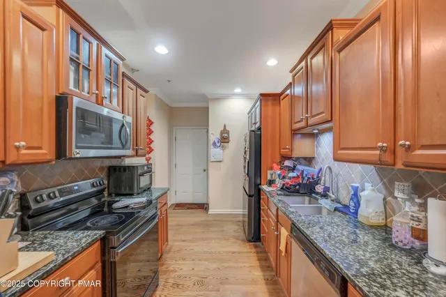 a kitchen with stainless steel appliances granite countertop a sink stove and cabinets