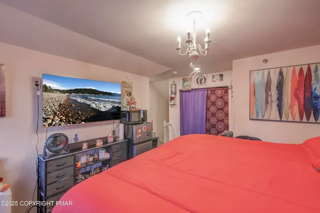 a bedroom with a bed and a flat screen tv