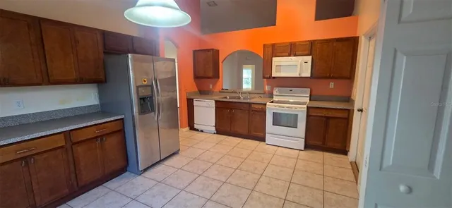a kitchen with stainless steel appliances granite countertop a refrigerator and a stove top oven