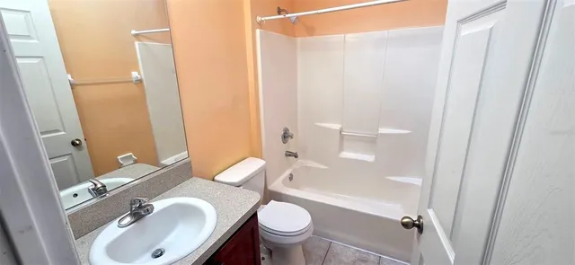 a bathroom with a granite countertop sink toilet and a mirror