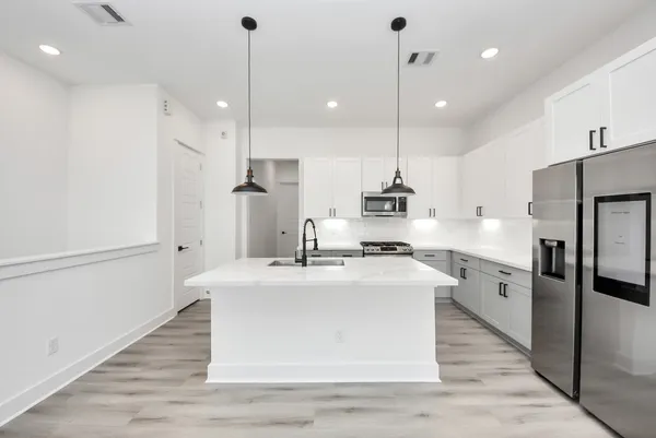 a large white kitchen with refrigerator stove and oven
