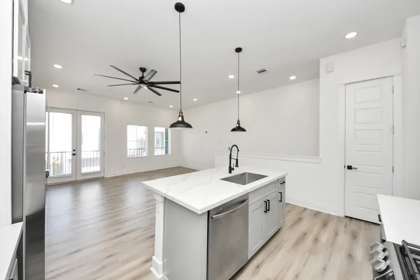a kitchen with a sink chandelier and wooden floor