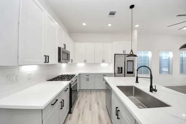 a kitchen with a sink stove top oven and cabinets