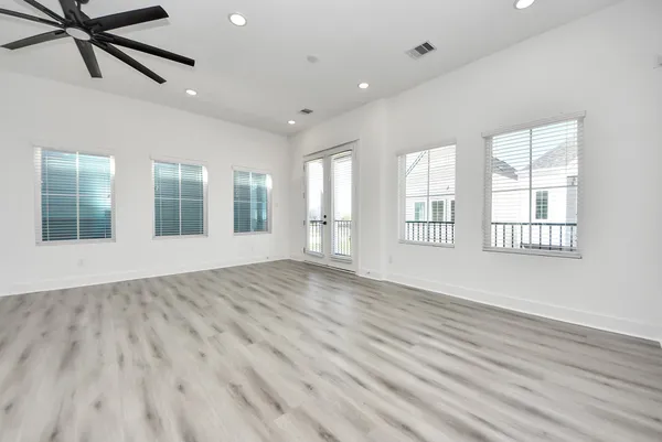 a view of an empty room with a window and wooden floor