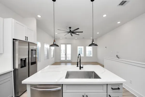 a kitchen with a sink a refrigerator and chairs