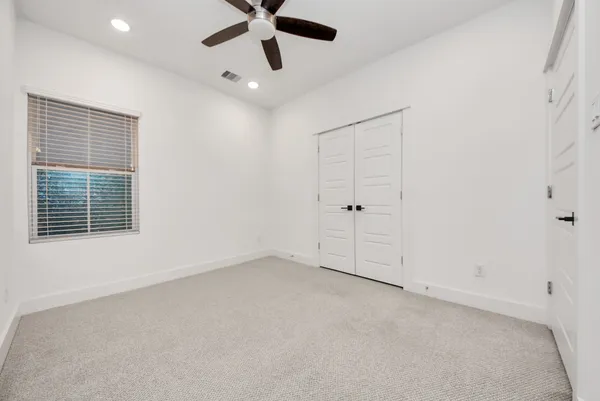 an empty room with a window and a ceiling fan