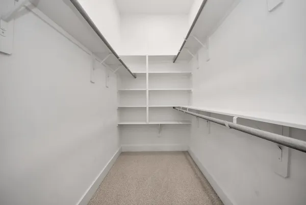 a view of walk in closet with empty racks