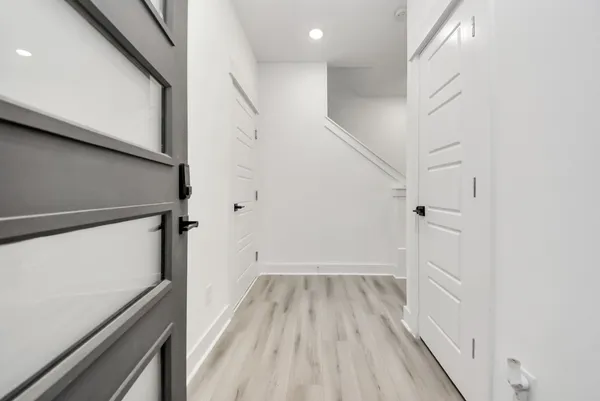a view of a hallway with wooden floor and staircase