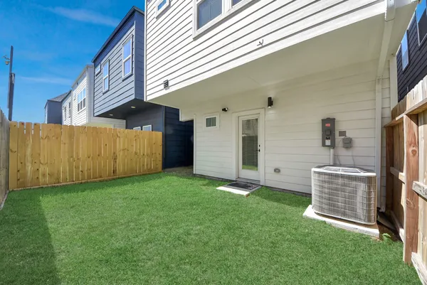 a view of an house with backyard space and wooden fence