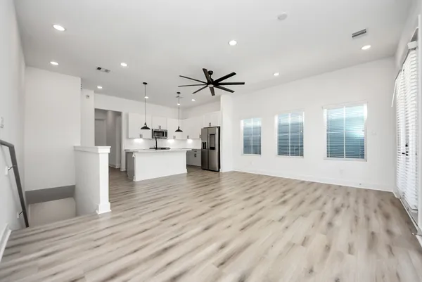 a view of a kitchen with refrigerator and wooden floor
