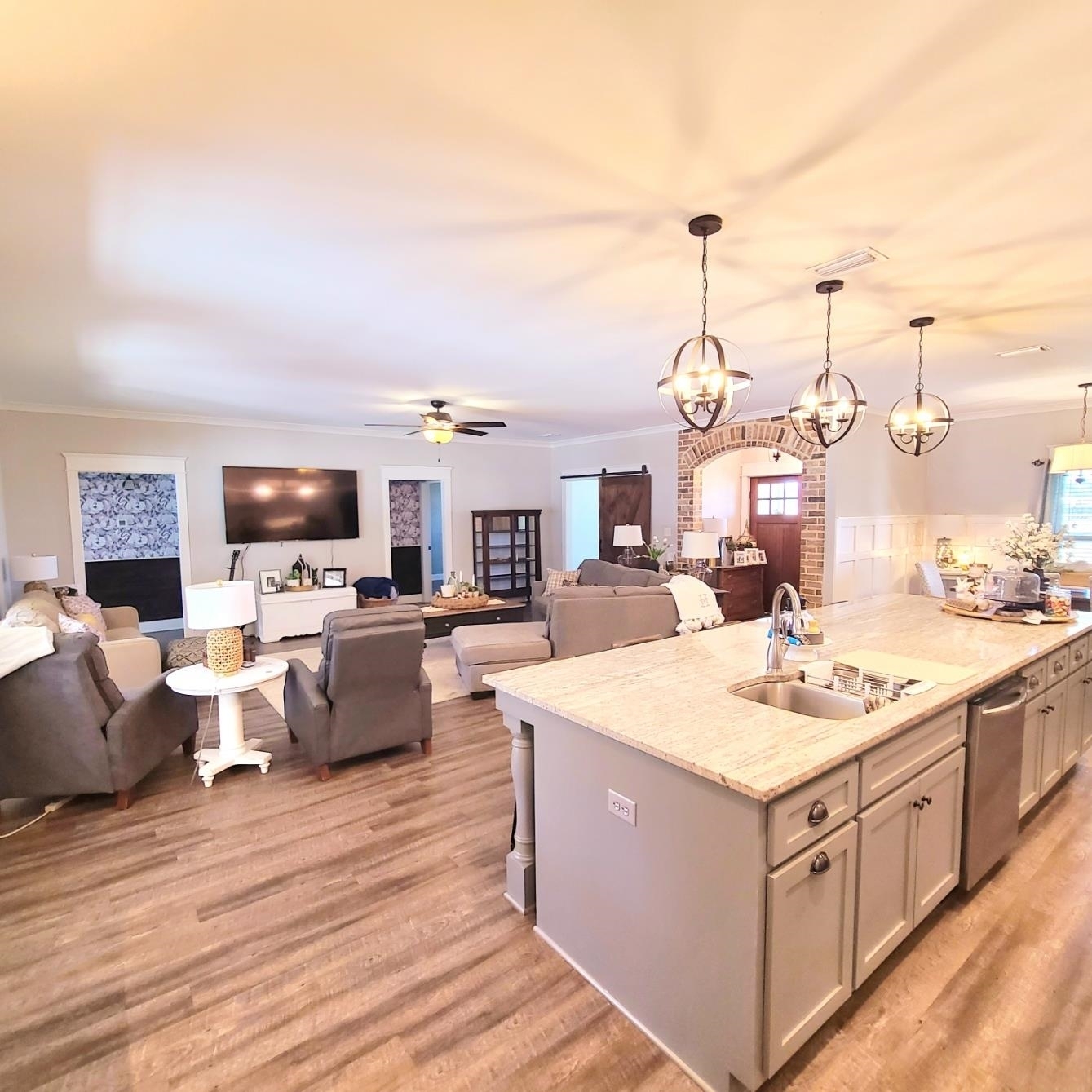 10051 Blackwell Nursery Road Semmes, AL 36575 - Photo 53 of 54 Kitchen featuring open floor plan, ornamental molding, a center island with sink, suspended lighting, and light stone counters
