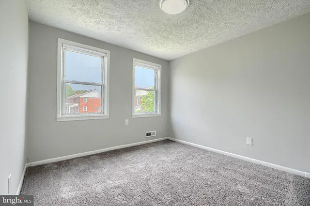 a bathroom with a granite countertop toilet a sink and a window