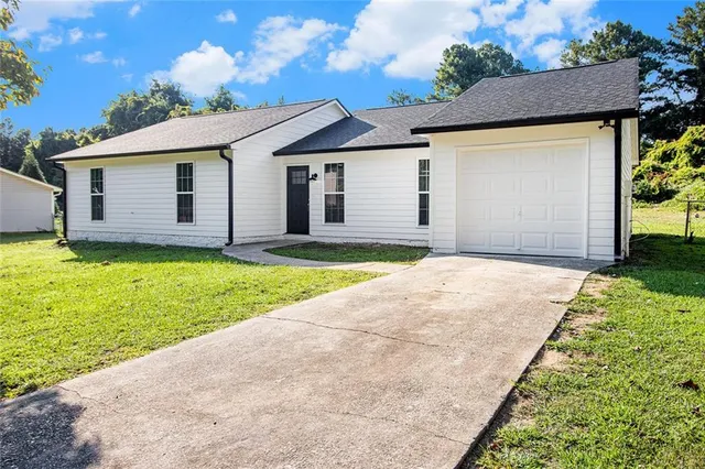 a front view of house with yard and garage
