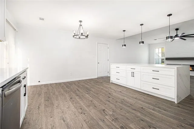 a kitchen with a wooden floor and white cabinets