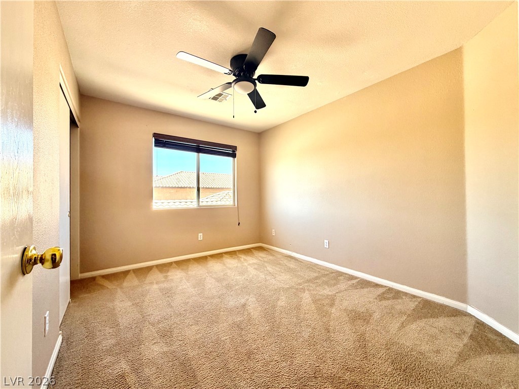 3936 Gold Point Street Las Vegas, NV 89129 - Photo 9 of 23 A well-lit bedroom features plush carpet and a convenient ceiling fan for comfort.