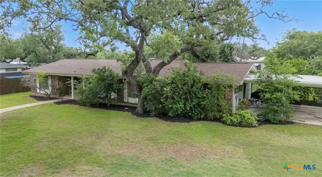 a view of a house with a yard and sitting area