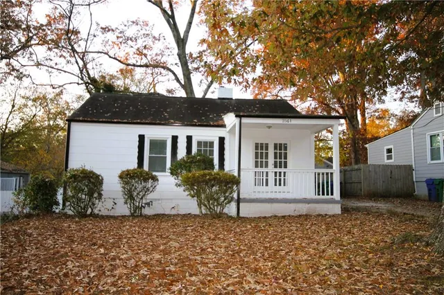 a view of a house with a backyard and a tree