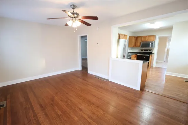 a view of a kitchen with wooden floor and a ceiling fan