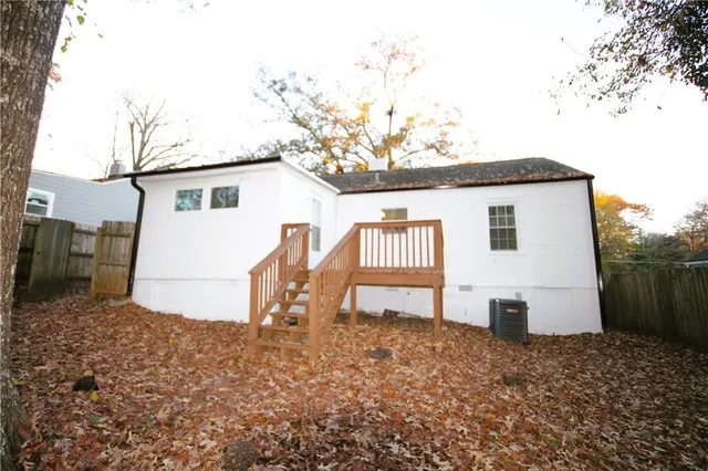 a view of a house with a backyard and a tree