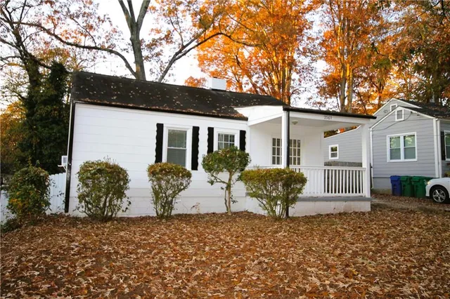 a view of a house with backyard and a tree