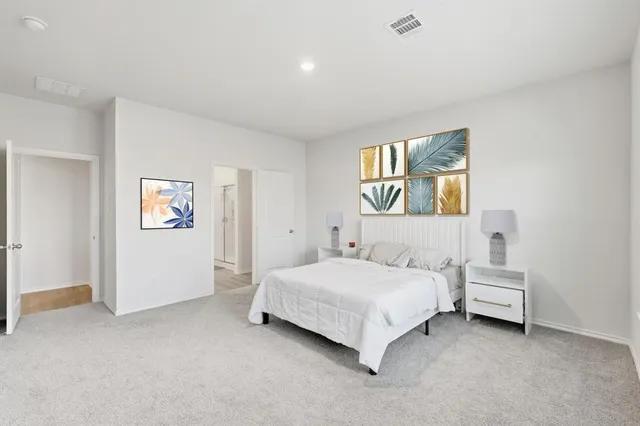 a spacious bedroom with a bed and a window