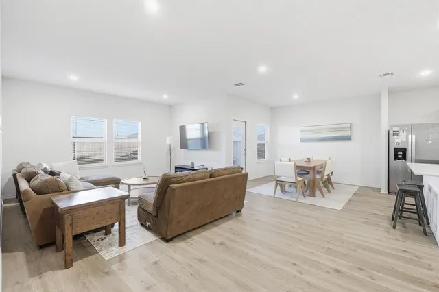 a living room with furniture a dining table and a wooden floor