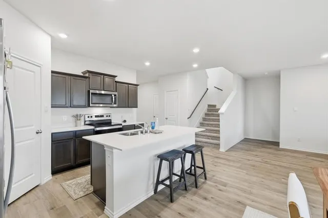 a kitchen with appliances cabinets and wooden floor